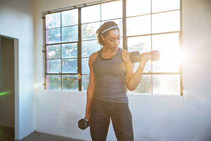 A woman lifts dumbbells in the gym