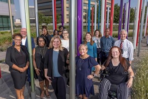 14 men and women stand among light tubes in UT Southwestern's Forest of Light