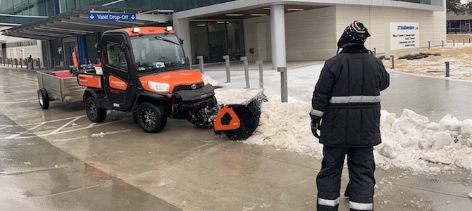 A snowplow on a sidewalk